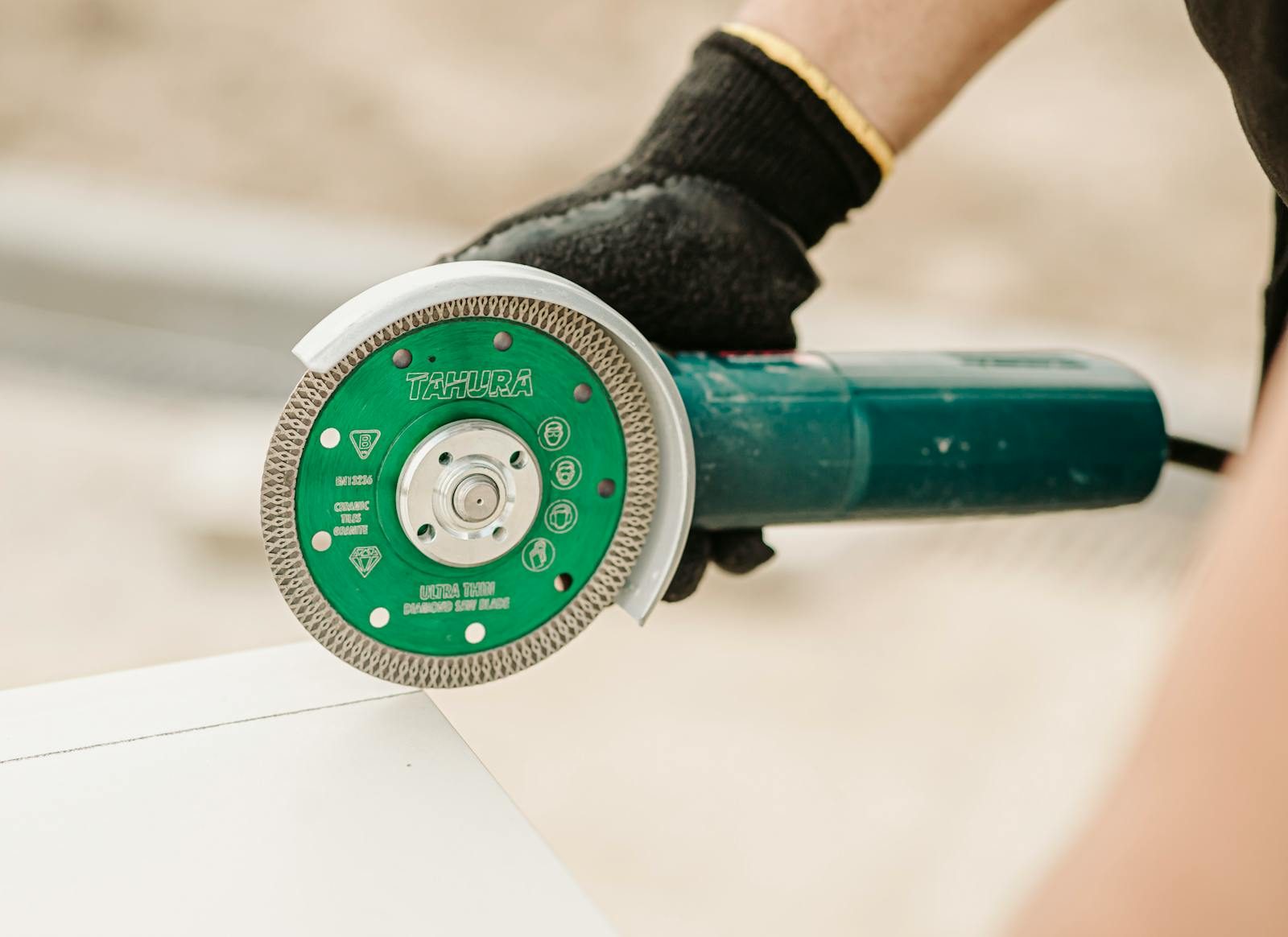 Close-up of a worker using an angle grinder with diamond blade for house renovation.